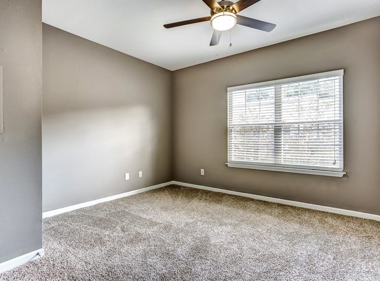 Upgraded bedroom with neutral paint, carpet, and ceiling fan